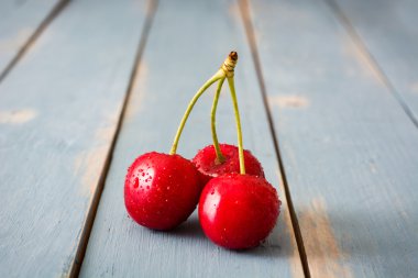 Mavi ahşap bir masa üzerinde lezzetli kiraz