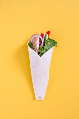 Mexican chicken fajita with peppers lettuce and onion on yellow background clipart
