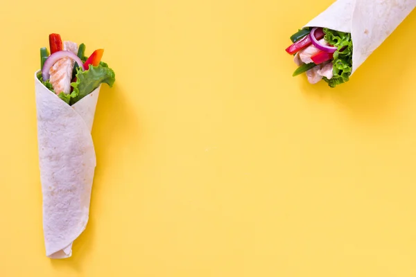 Fajita de pollo mexicano con pimientos lechuga y cebolla sobre fondo amarillo —  Fotos de Stock