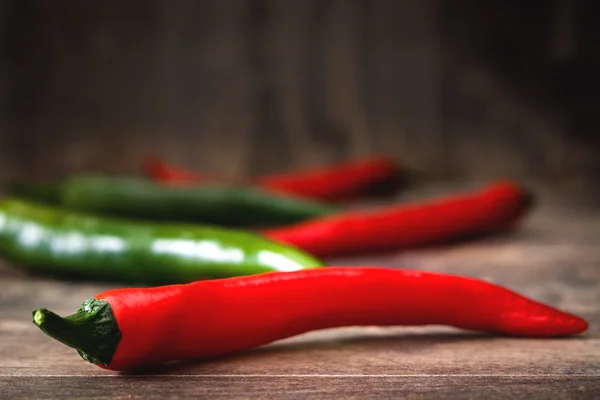 Red hot chili peppers on rustic wooden background — Stock Photo, Image