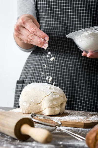 Woman making bread with her hand on wood table