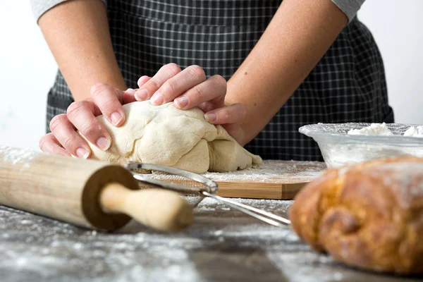 Mujer haciendo pan con la mano sobre la mesa de madera — Foto de Stock