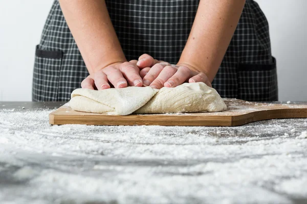 Mujer haciendo pan con la mano sobre la mesa de madera — Foto de Stock