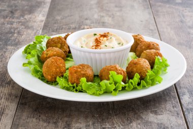 Rustik ahşap bir masa üzerinde sebze ve vejeteryan falafels
