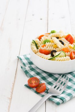 Beyaz ahşap masa üzerinde bir kapta makarna salatası