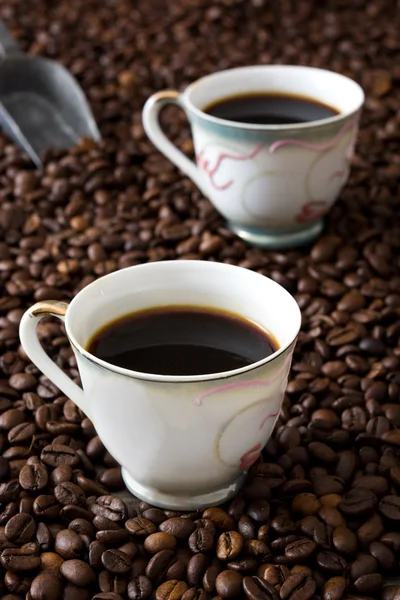 Káva šálek a kávová zrna pozadí — Stock fotografie