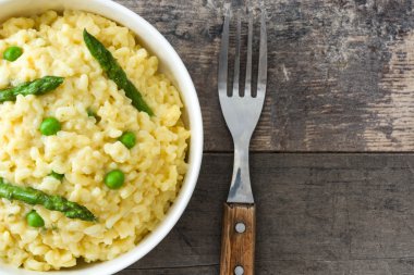Risotto ile kuşkonmaz, maydanoz ve bezelye bir rustik ahşap tablo