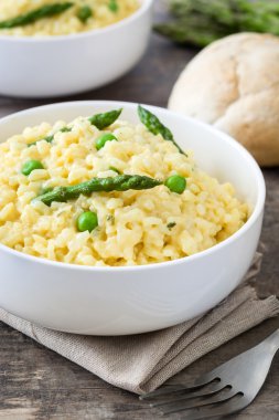 Risotto ile kuşkonmaz, maydanoz ve bezelye bir rustik ahşap tablo