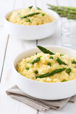 Risotto ile kuşkonmaz, maydanoz ve bezelye bir beyaz ahşap tablo