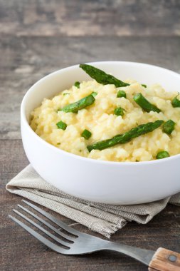 Risotto ile kuşkonmaz, maydanoz ve bezelye bir rustik ahşap tablo