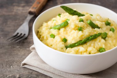 Risotto ile kuşkonmaz, maydanoz ve bezelye bir rustik ahşap tablo