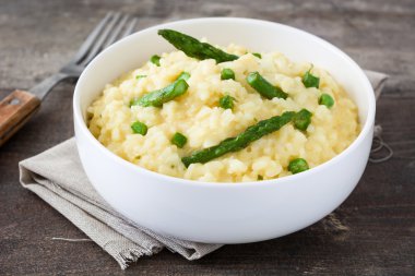 Risotto ile kuşkonmaz, maydanoz ve bezelye bir rustik ahşap tablo