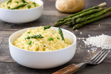 Risotto ile kuşkonmaz, maydanoz ve rustik ahşap bir masa üzerinde bir kase bezelye