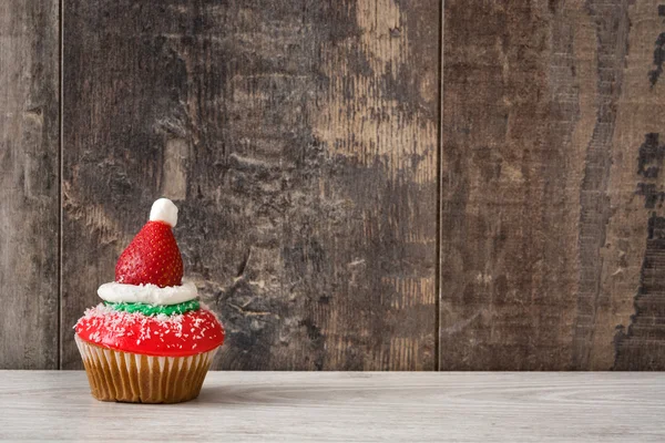 Weihnachtsmütze Cupcake auf Holz Hintergrund — Stockfoto