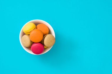 Mavi arka plan üzerinde renkli macaroons