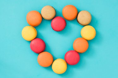 Kalp şeklinde mavi arka plan üzerinde renkli macaroons