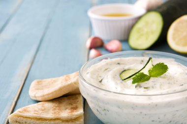 Cacık ve malzemelerin mavi ahşap bir masa üzerine