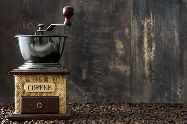 咖啡研磨机和咖啡豆仿古木制背景 — 图库照片