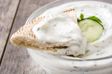 Bir rustik ahşap tabloda cacık ve pide ekmek