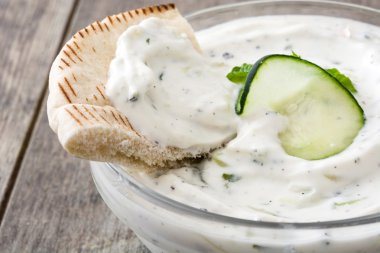 Bir rustik ahşap tabloda cacık ve pide ekmek