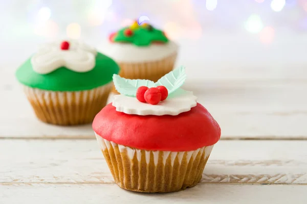 Cupcake de Natal e luzes no fundo de madeira branco — Fotografia de Stock