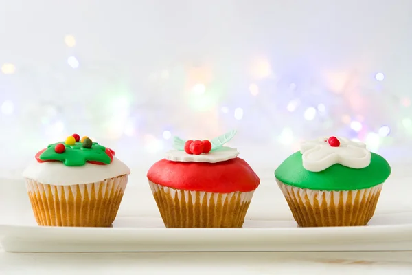 Cupcake de Natal e luzes no fundo de madeira branco — Fotografia de Stock