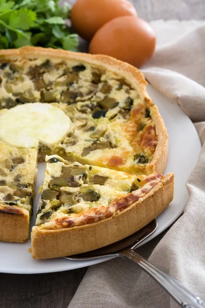 Französische Quiche mit Gemüse auf einem rustikalen Holztisch — Stockfoto