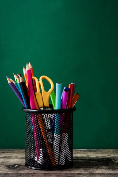 Fournitures scolaires sur une table en bois et fond de tableau noir — Photo