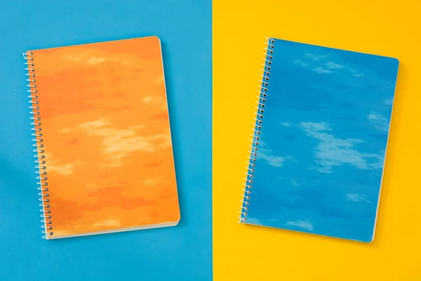 Zwei Notizbücher auf blauem und gelbem Hintergrund — Stockfoto