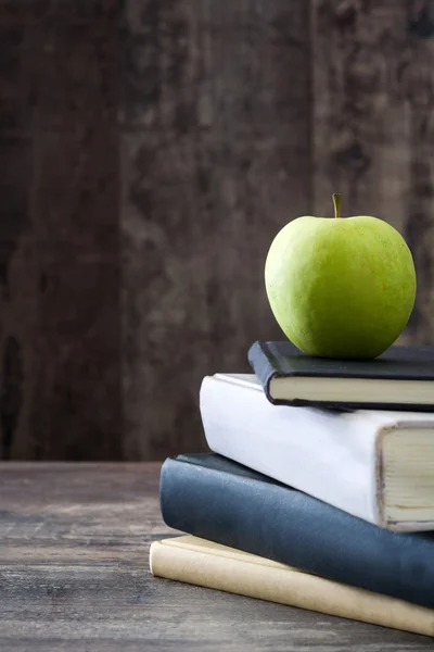 Persediaan sekolah dan apel hijau pada latar belakang kayu pedesaan — Stok Foto