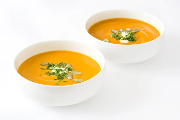 Pumpkin soup with cream and pumpkin seeds isolated on white background — Stock Photo, Image