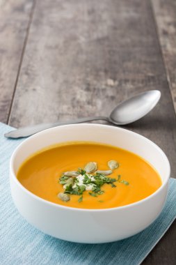 Balkabağı çorbası ve kabak çekirdeği rustik ahşap zemin üzerine