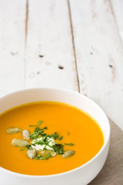 Beyaz ahşap bir masa üzerinde balkabağı çorbası