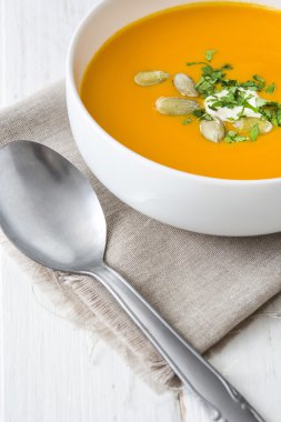 Beyaz ahşap bir masa üzerinde balkabağı çorbası