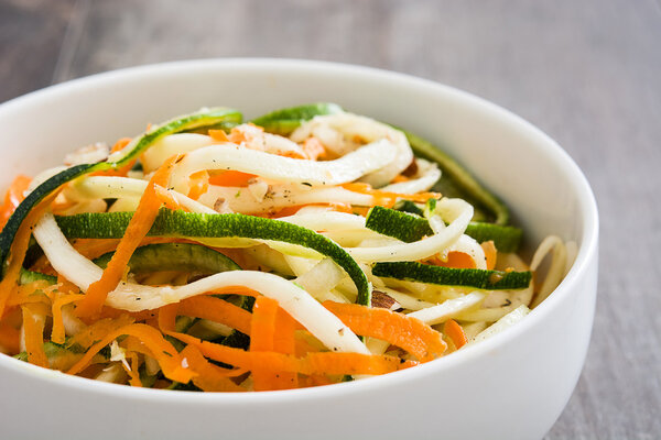 Carrot and zucchini noodles on a rustic wooden table