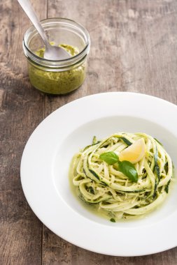 Ahşap masa üzerinde pesto soslu kabak erişte