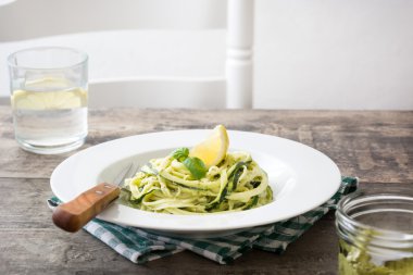 Ahşap masa üzerinde pesto soslu kabak erişte