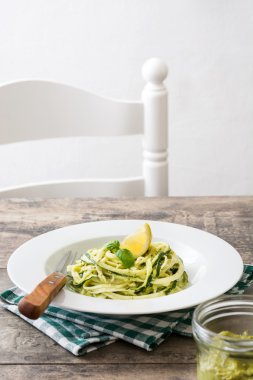 Ahşap masa üzerinde pesto soslu kabak erişte