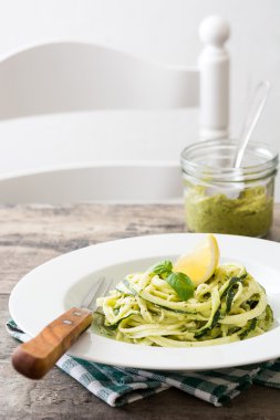 Ahşap masa üzerinde pesto soslu kabak erişte