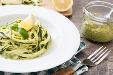 Ahşap masa üzerinde pesto soslu kabak erişte
