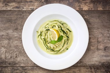 Ahşap masa üzerinde pesto soslu kabak erişte