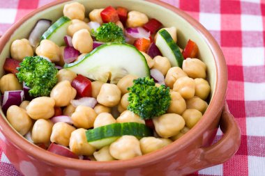 Damalı masa örtüsü üzerinde nohut salatası