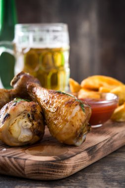 Kızartma tavuk sopaları ile cips ve bira ahşap arka plan üzerinde