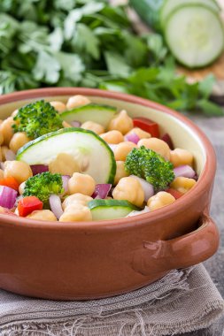 Ahşap arka plan üzerinde kahverengi kase nohut salatası