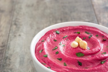 Ahşap masa üzerinde bir kasede pancar humus