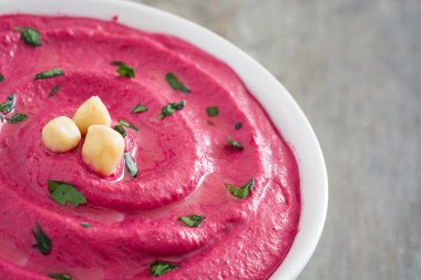 Ahşap masa üzerinde bir kasede pancar humus