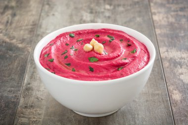 Ahşap masa üzerinde bir kasede pancar humus