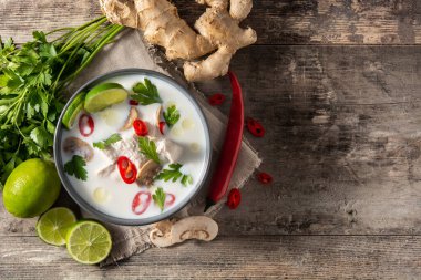 Geleneksel Tayland yemekleri kasede Tom Kha Gai ve ahşap masada malzemeler. Boşluğu kopyala