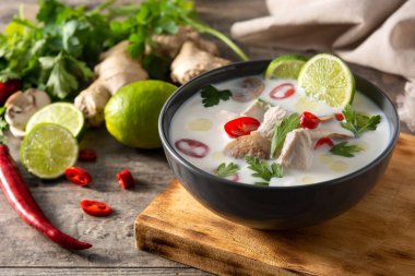 Geleneksel Tayland yemeği Tom Kha Gai ve ahşap masadaki malzemeler.