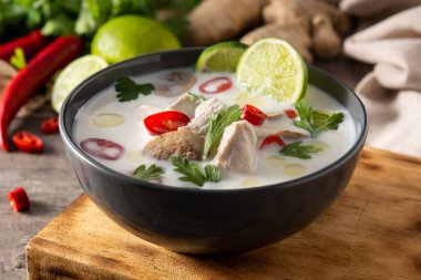 Geleneksel Tayland yemeği Tom Kha Gai ve ahşap masadaki malzemeler.
